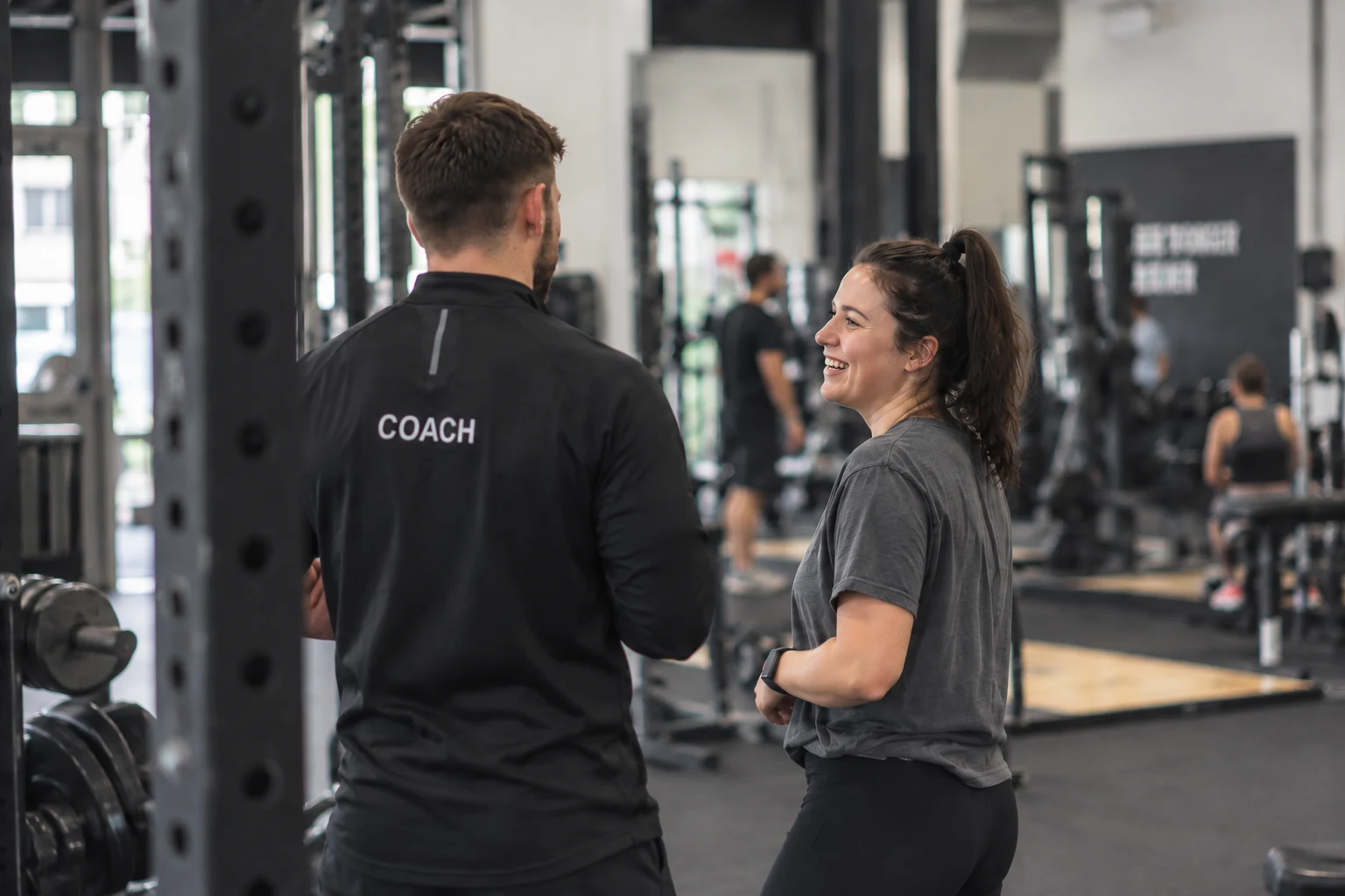 A coach and member talking on the gym floor